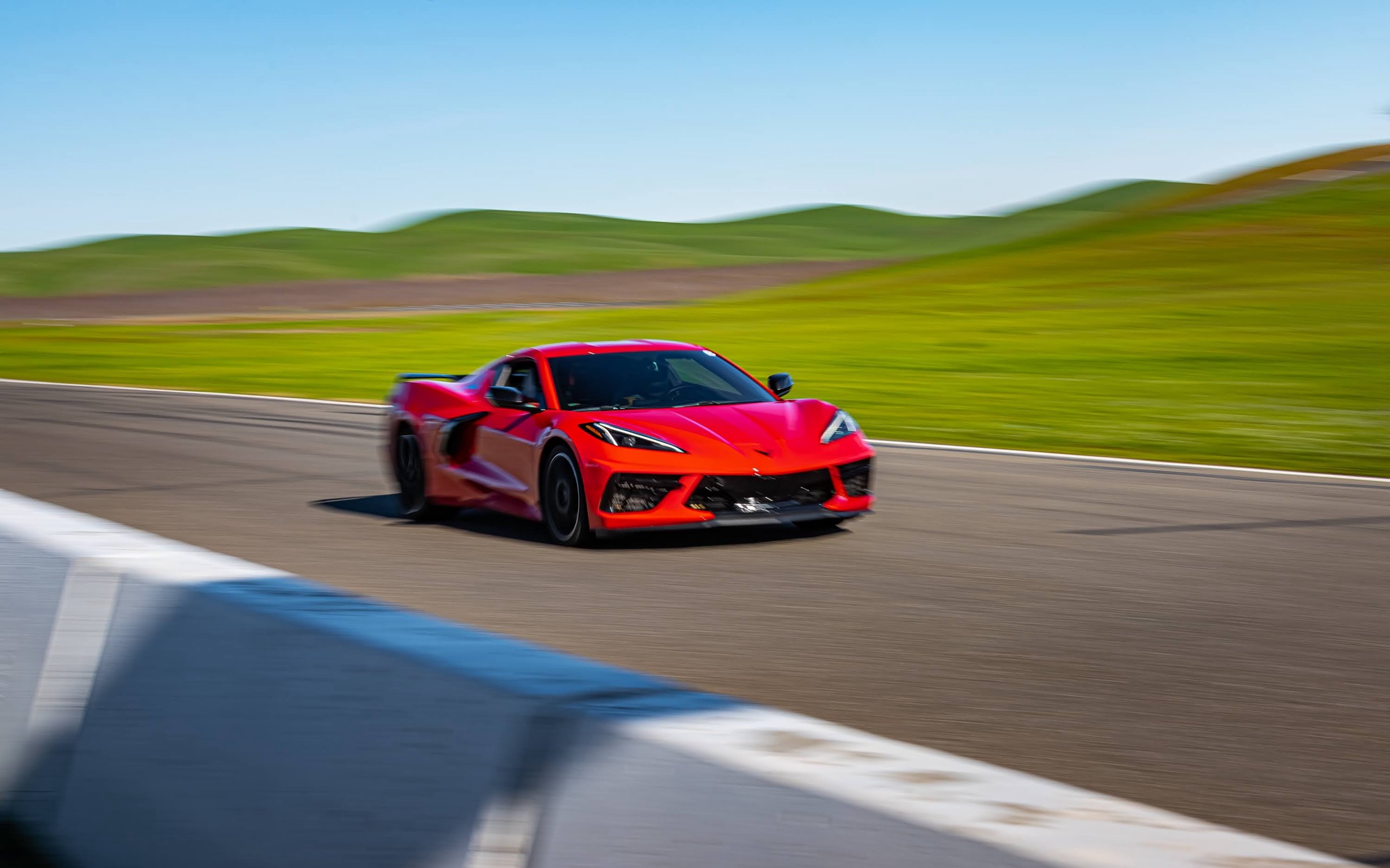 Red C8 Corvette panning shot at speed on track